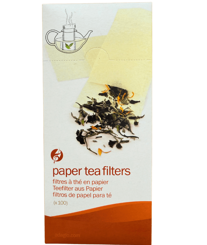 Box of paper tea filters with tea leaves on a white background