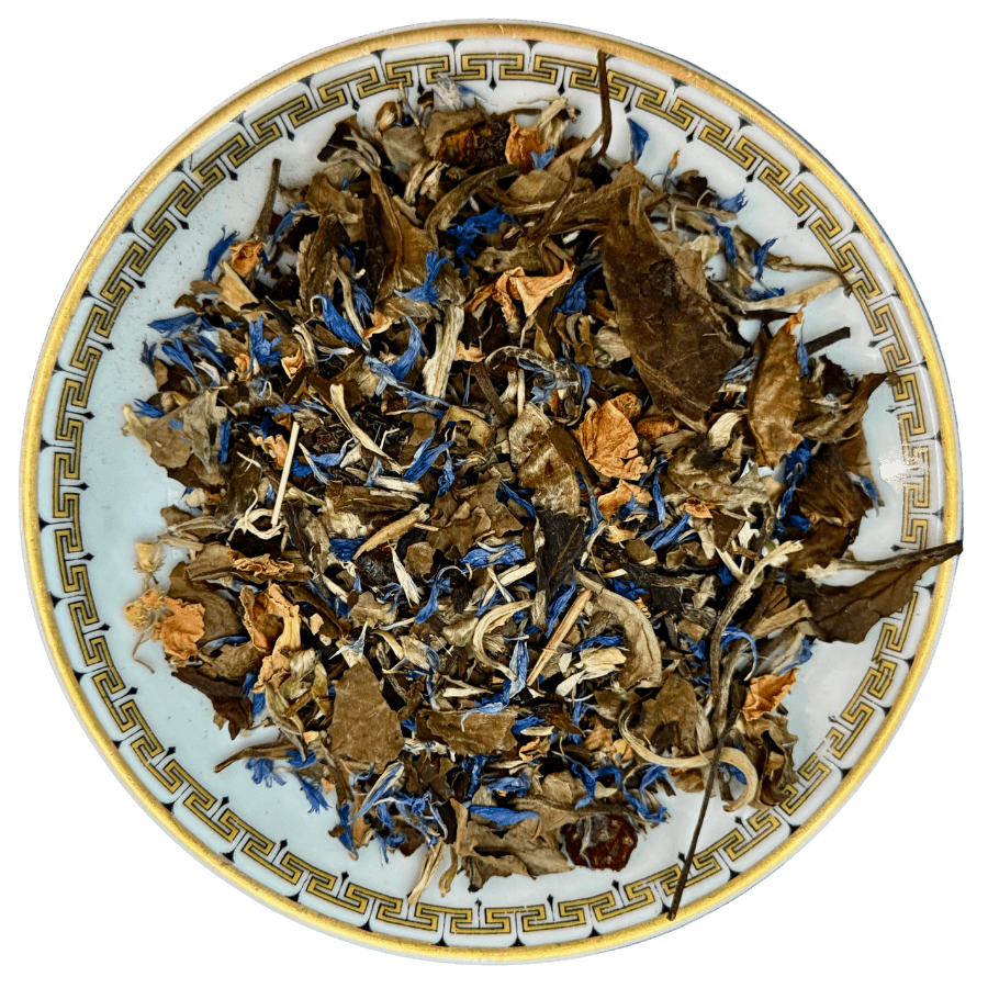 Assorted dried herbs and flowers on a decorative ceramic plate