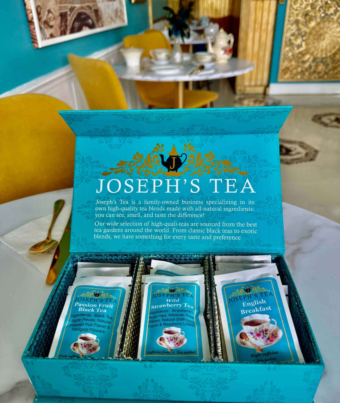 Open turquoise box of Joseph's Tea with tea bags on a table.