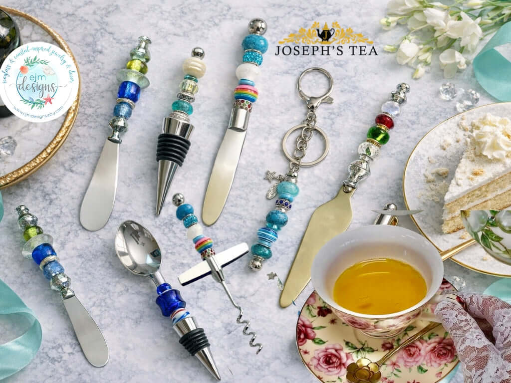 Set of decorative cutlery with beaded handles on a table setting with tea and cake.