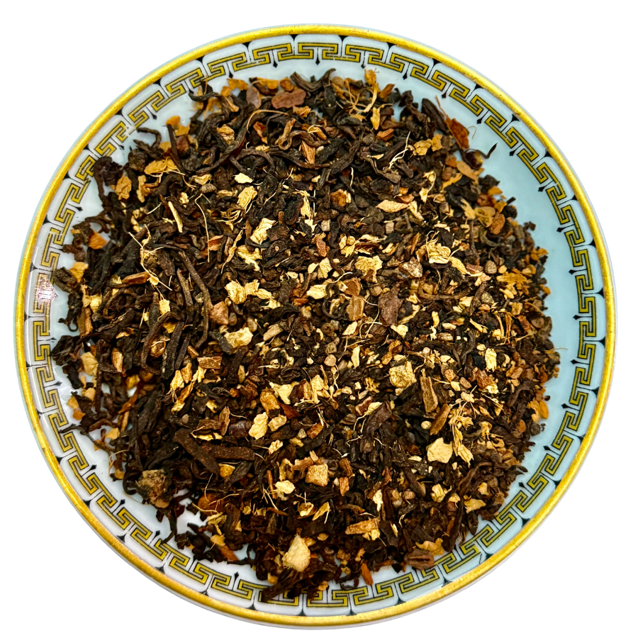 Tea leaves on a decorative ceramic plate with a white background