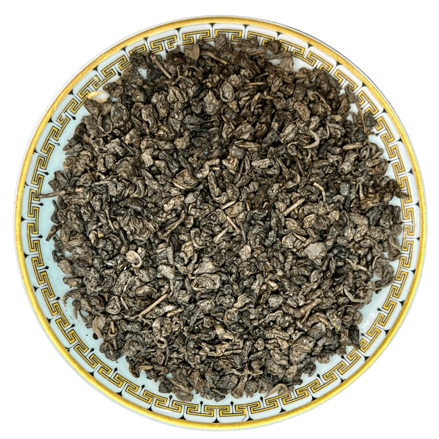 Dry tea leaves on a decorative ceramic plate with a white background