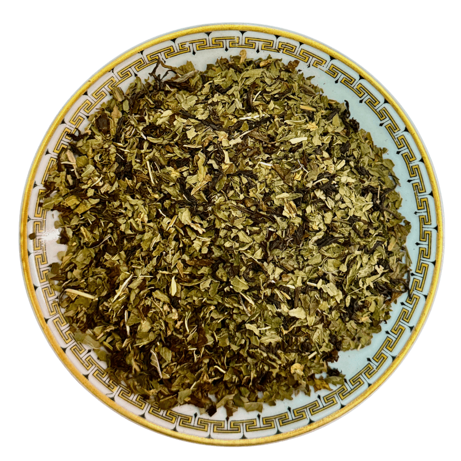Dry green herbs on a decorative ceramic plate with a white background
