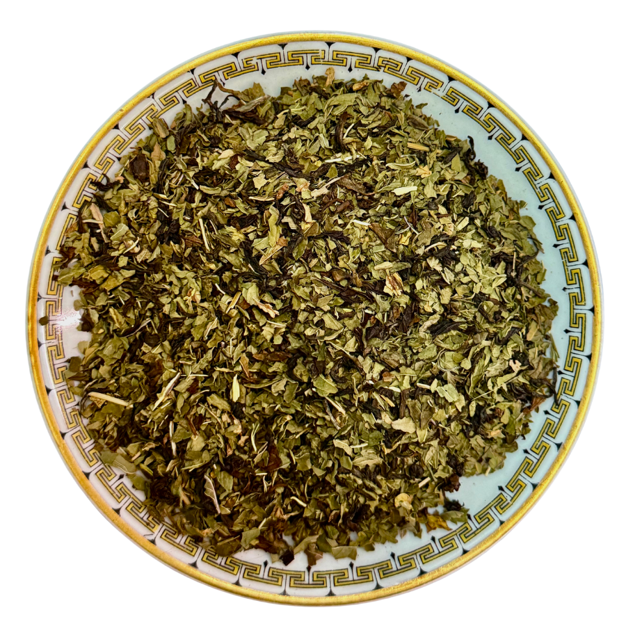 Dry green herbs on a decorative ceramic plate with a white background