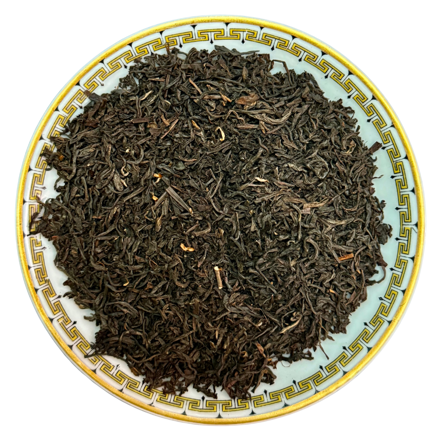 Tea leaves on a decorative ceramic plate with a white background