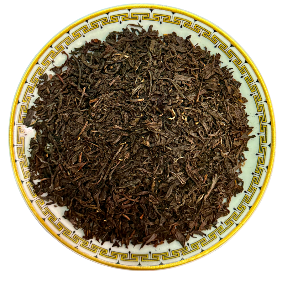 Dry black tea leaves on a decorative ceramic plate