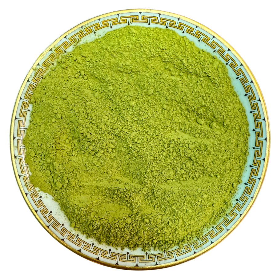 Green powder on a decorative plate with a white background