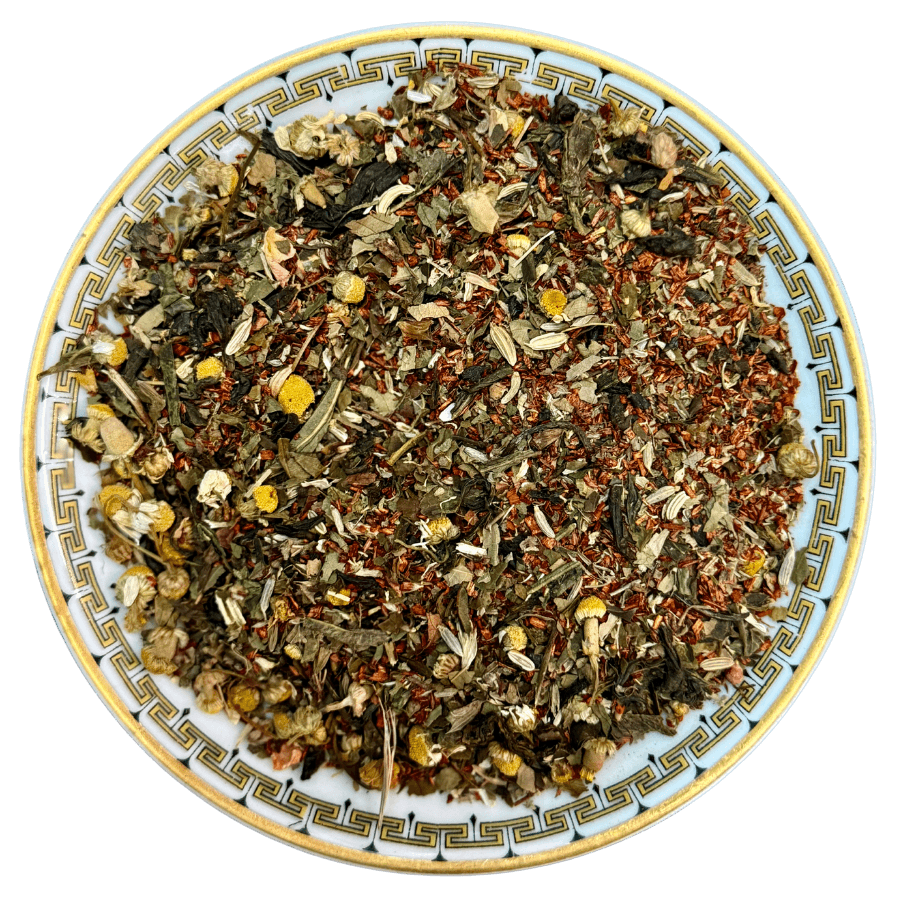 Assorted dry herbs and leaves on a decorative plate with a white background