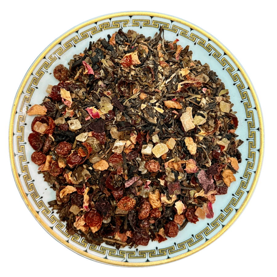 Assorted dried tea leaves on a decorative plate with a white background