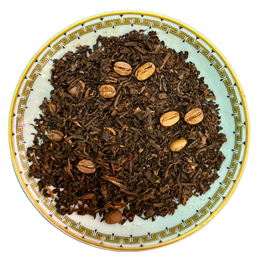 Roasted coffee beans and tobacco leaves on a decorative plate with a white background