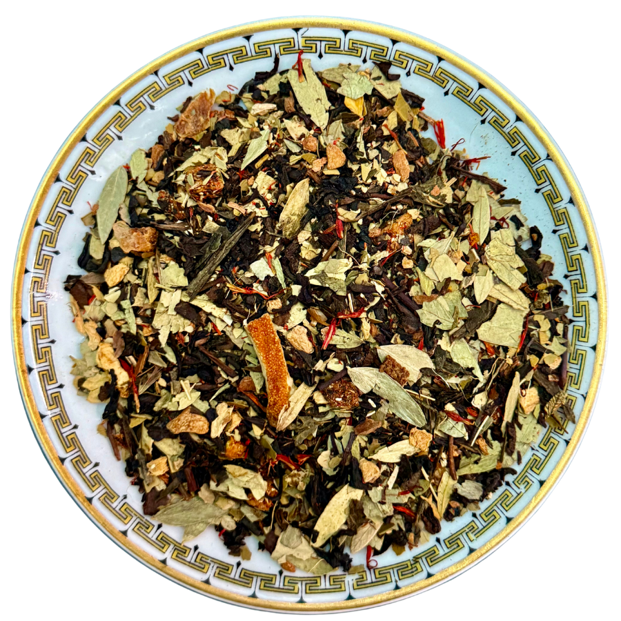 Assorted dried herbs and leaves on a decorative plate with a white background