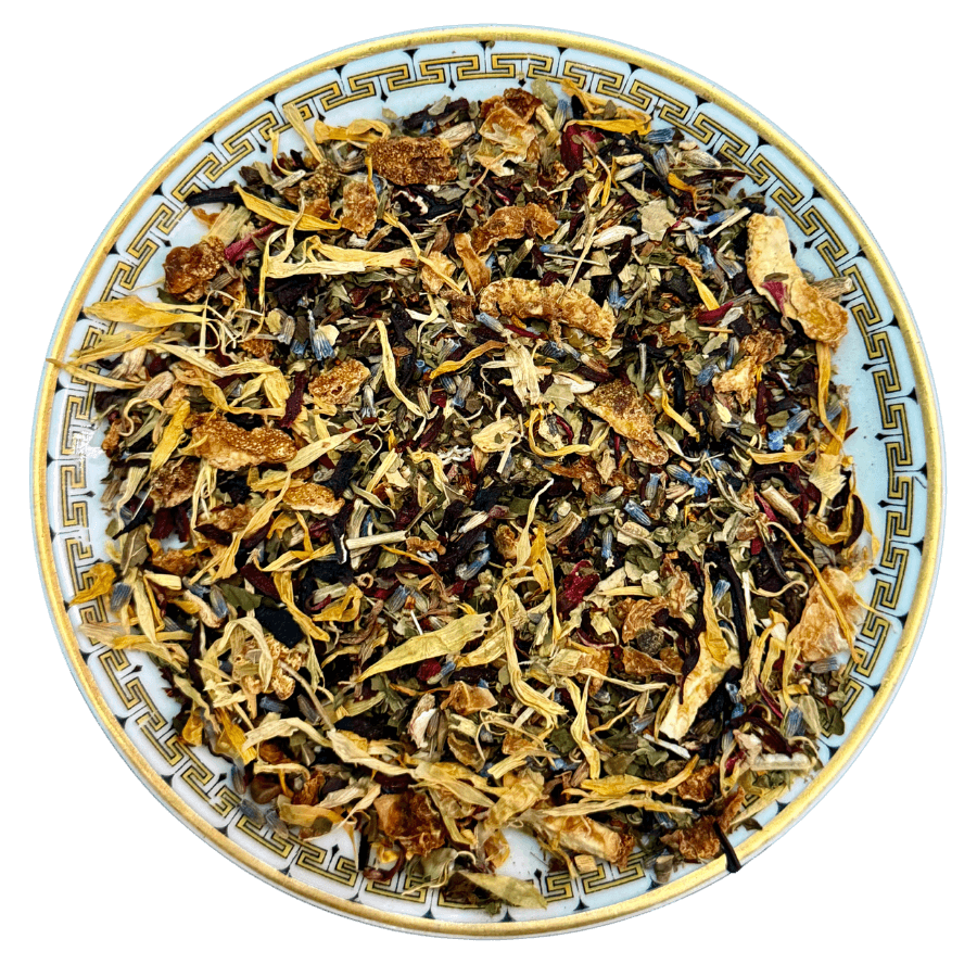 Assorted dried herbs and flowers on a decorative plate with a white background