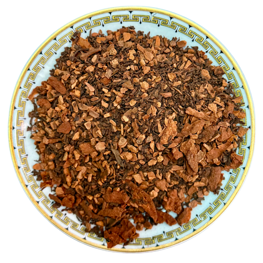 Dried herbs or spices on a decorative plate with a white background