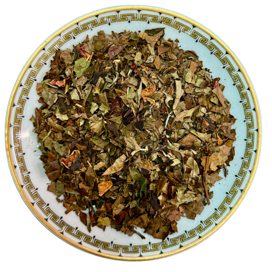 Dry herbs on a decorative plate with a white background